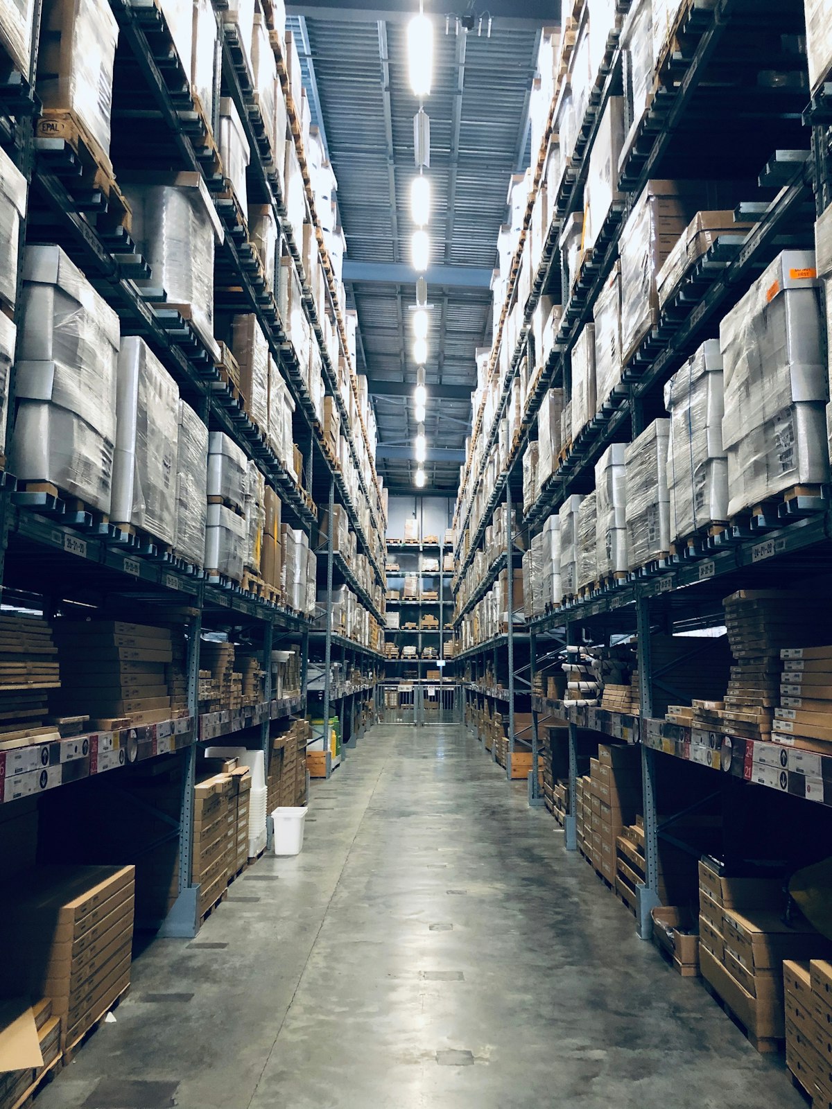 Pasillo de bodega con mercancía en estantería industrial